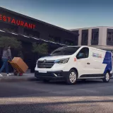 Trafic e-tech park on the street next to a restaurant and a person is walking to it